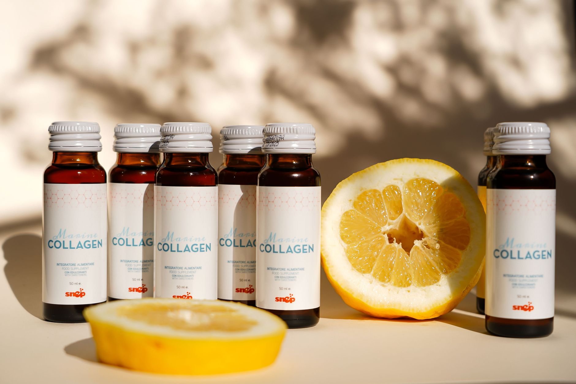 Collagen supplement bottles with lemon slice in bright light.